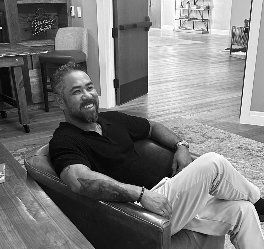 Man smiling while seated in a leather armchair